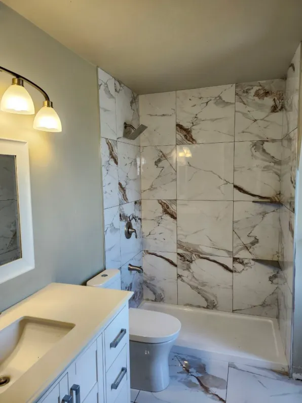 Vein-matched Calacatta marble bathroom wall and shower bench — luxury Victoria bath