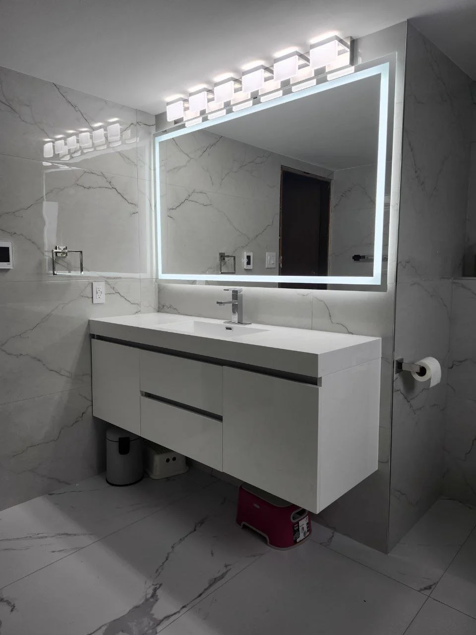 Modern bathroom vanity with backlit LED mirror and marble walls — Victoria, BC renovation